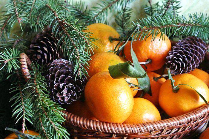 Веточки хвои и мандарины на новогоднем столе